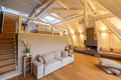 a living room with a white couch and a fireplace at Park Mansion Hotel in Amsterdam