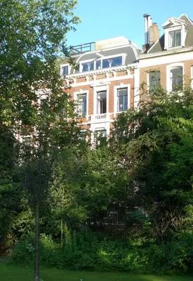 a large brick building in the middle of trees at Park Mansion Hotel in Amsterdam