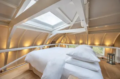 a bedroom with a white bed and a skylight at Park Mansion Hotel in Amsterdam