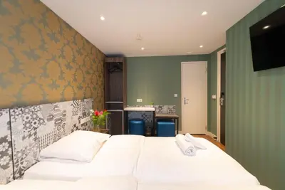 a bedroom with a white bed and a green wall at The Old Nickel Hotel in Amsterdam