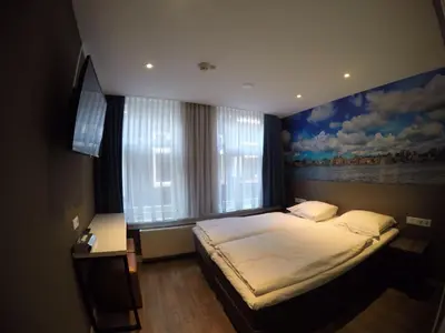 a bedroom with a bed with a painting on the wall at The Old Nickel Hotel in Amsterdam