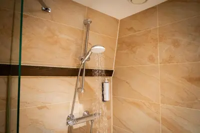a shower with a shower head in a bathroom at The Old Nickel Hotel in Amsterdam