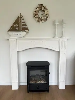 a white mantle with a fireplace in a living room at Vakantiebungalow in Riviera Maison stijl nabij zee en strand, bos en duin in Warmenhuizen
