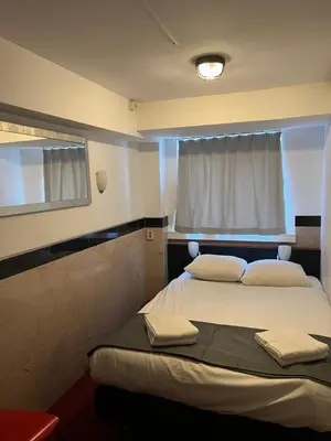 a bedroom with two beds and a window at MAX Hotel Amsterdam in Amsterdam