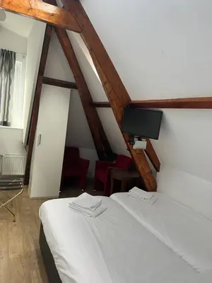 a bedroom with two beds and a flat screen tv at MAX Hotel Amsterdam in Amsterdam