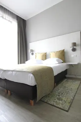 a bedroom with a large bed and a window at Apple Inn Hotel in Amsterdam