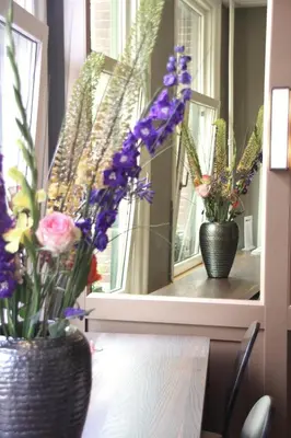 two vases filled with flowers sitting on a window sill at Apple Inn Hotel in Amsterdam