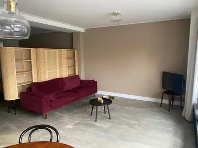 a living room with a red couch and a table at Urban stay Zuid in Amersfoort
