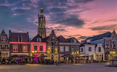 a group of buildings with a clock tower at sunset at Urban stay Zuid in Amersfoort
