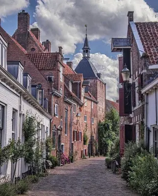 a cobblestone street in a city with brick buildings at Urban stay Zuid in Amersfoort