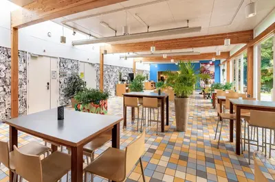 a restaurant with tables and chairs and potted plants at Stayokay Hostel Egmond in Egmond-Binnen