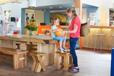 a woman and a little girl sitting on a bench at Stayokay Hostel Egmond in Egmond-Binnen