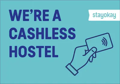 a hand holding a phone with the words were a cashless hospital at Stayokay Hostel Egmond in Egmond-Binnen