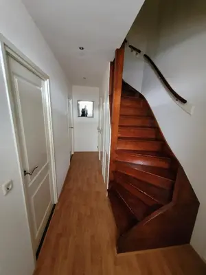 a hallway with a wooden staircase in a house at Appartement 
