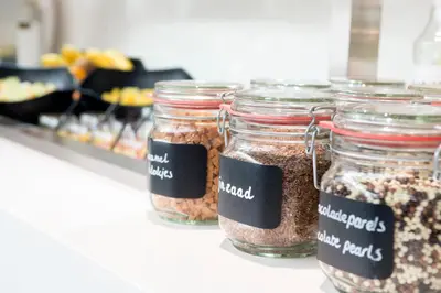 a row of jars filled with nuts on a counter at Hotel De Zoete Inval Haarlemmerliede in Haarlem