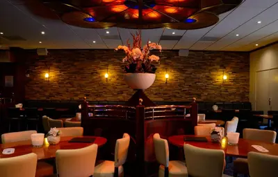 a restaurant with tables and chairs and a vase of flowers at Hotel De Zoete Inval Haarlemmerliede in Haarlem