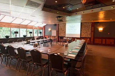 a conference room with tables and chairs and a screen at Hotel De Zoete Inval Haarlemmerliede in Haarlem