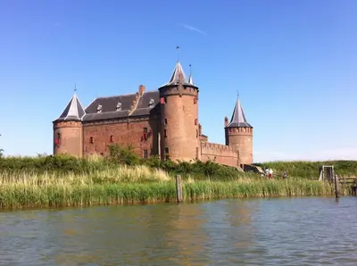 a castle on a hill next to a body of water at Floating B&B Amsterdam in Amsterdam