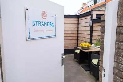 a door leading to a patio with a table at Strand83 in Egmond aan Zee