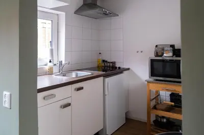 a small kitchen with a sink and a microwave at Strand83 in Egmond aan Zee