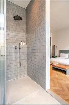 a bathroom with a shower and a bedroom with a bed at Vondel 99 in Amsterdam