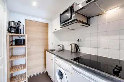 a small kitchen with a sink and a microwave at Appartement en Studio Papillon in Zandvoort