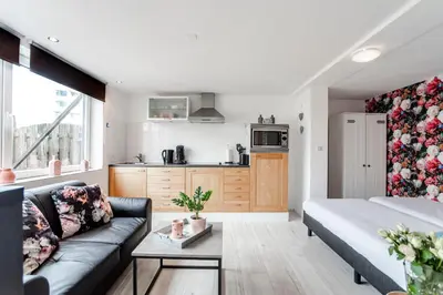 a living room with a couch and a kitchen at Appartement en Studio Papillon in Zandvoort