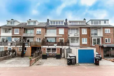 a large brick apartment building with a blue garage at Appartement en Studio Papillon in Zandvoort