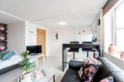 a living room with a couch and a desk at Appartement en Studio Papillon in Zandvoort