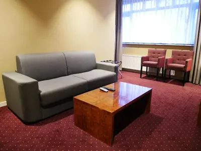a living room with a couch and a coffee table at Hotel het Oosten in Alphen aan den Rijn