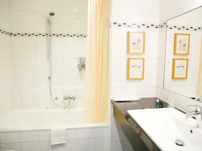 a bathroom with a shower and a sink and a tub at Hotel het Oosten in Alphen aan den Rijn