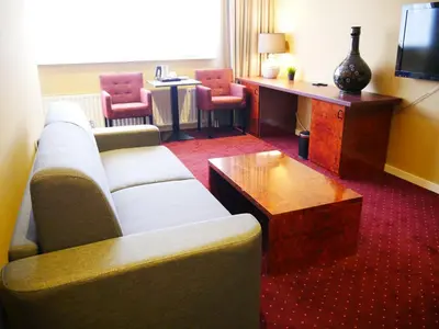 a living room with a couch and a table at Hotel het Oosten in Alphen aan den Rijn
