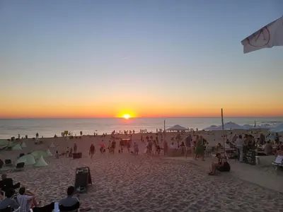 a crowd of people on a beach at sunset at Appartement Canberra. in Bergen aan Zee