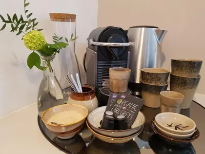 a table with cups and a coffee maker and a vase at The Superstay Boutique guestroom in Amsterdam