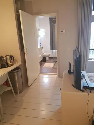 a room with a living room with a television on a table at The Superstay Boutique guestroom in Amsterdam