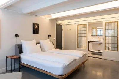 a bedroom with a large bed with white sheets at This Must Be The Place in Utrecht