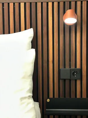 a bed with a pillow and a lamp on a wall at This Must Be The Place in Utrecht