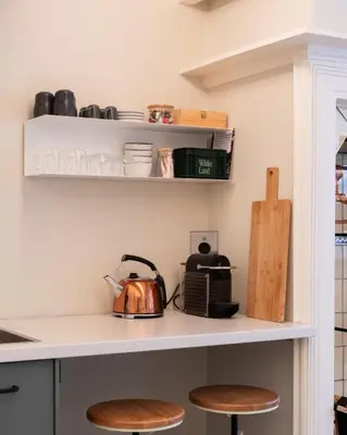 a kitchen with a counter with a tea kettle and stools at This Must Be The Place in Utrecht