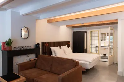 a bedroom with a bed and a couch and a bed at This Must Be The Place in Utrecht