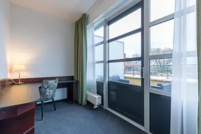 an office with a desk and a large window at Amrâth Hotel Alkmaar in Alkmaar