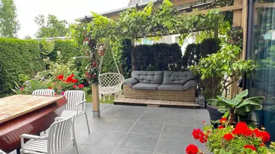 a patio with a couch on a swing at Two nice rooms in residential area with private bathroom in Almere