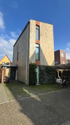 a tall building with a green door in front of it at Two nice rooms in residential area with private bathroom in Almere