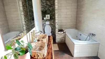 a bathroom with a tub and a toilet and a sink at Two nice rooms in residential area with private bathroom in Almere