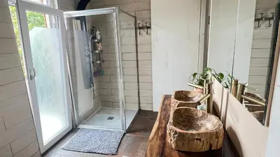 a bathroom with a wooden sink and a shower at Two nice rooms in residential area with private bathroom in Almere
