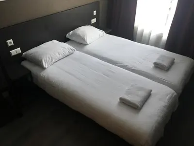 a large white bed with two towels on it at Hotel Manofa in Amsterdam