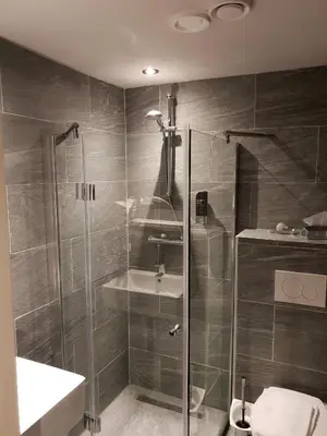 a bathroom with a shower and a toilet and a sink at Hotel Manofa in Amsterdam