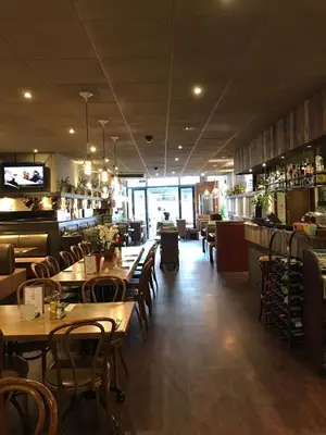 a restaurant with tables and chairs and a bar at Hotel Manofa in Amsterdam