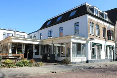 a large white building with windows on a street at Het Hart van Weesp in Weesp
