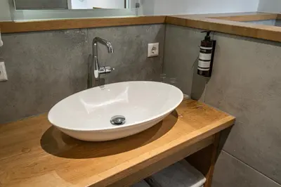 a white sink on a wooden counter in a bathroom at Het Hart van Weesp in Weesp