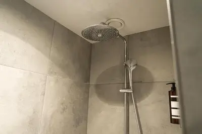 a shower with a shower head in a bathroom at Het Hart van Weesp in Weesp